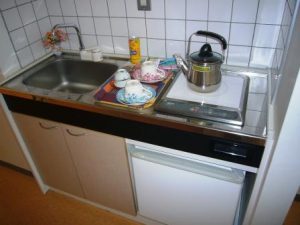施設のキッチンエリア。シンク、コンロ、食器棚が配置されている。